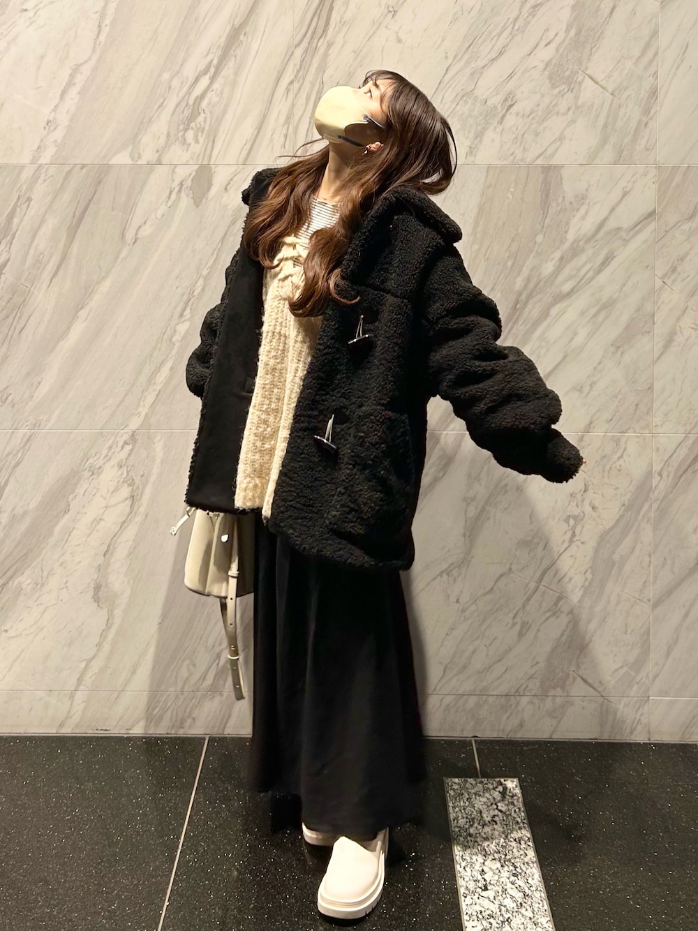 ブラック系のダッフルコート、ホワイト系のブーツ、ホワイト系のニット/セーターを着用したレディースの冬コーディネートの1枚目の写真