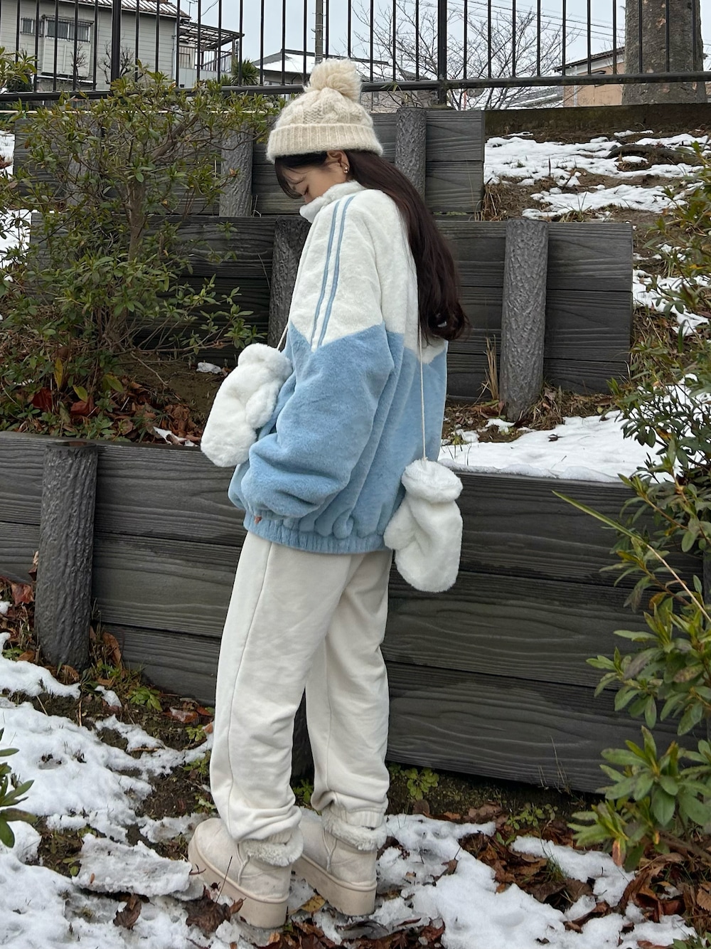 ホワイト系のスウェットパンツ、ブルー系のトップス、ホワイト系のブーツを着用したレディースの冬コーディネートの1枚目の写真