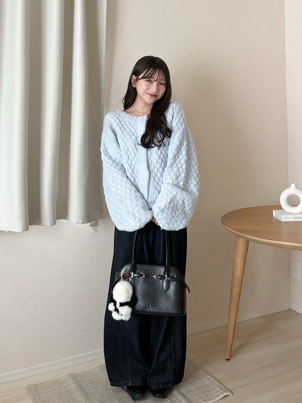 ブルー系のカーディガン/ボレロ、ブラック系のボストンバッグ、ブルー系のデニムパンツを着用したレディースの秋コーディネートの1枚目の写真