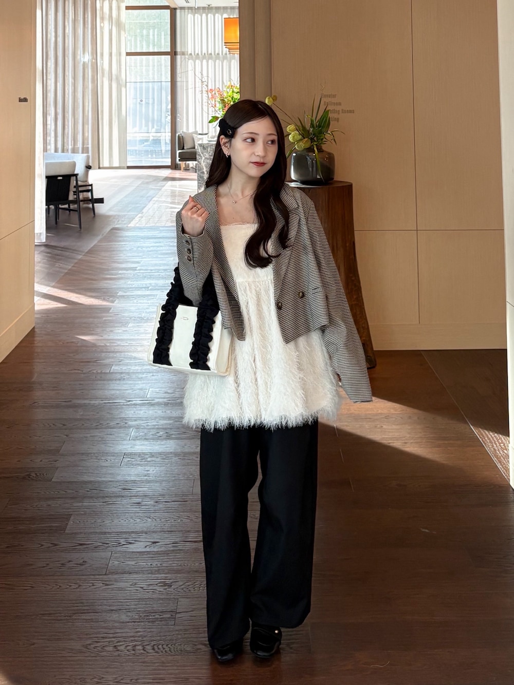 ホワイト系のキャミソール、ブラウン系のテーラードジャケット、ブラック系のスラックスを着用したレディースの秋コーディネートの1枚目の写真