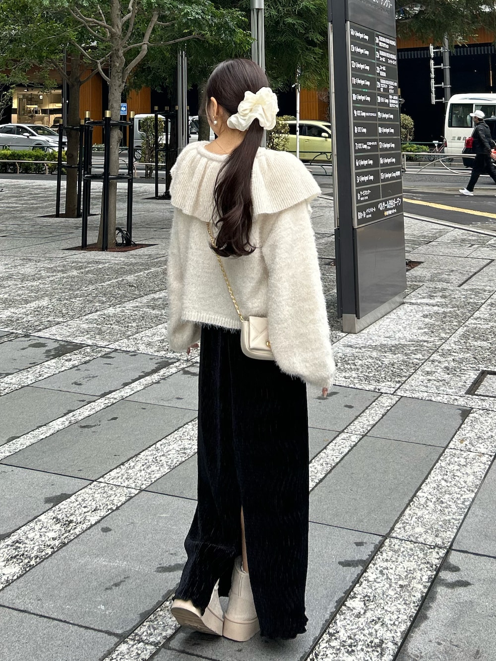 ブラック系のスカート、ホワイト系のショルダーバッグ、ホワイト系のニット/セーターを着用したレディースの冬コーディネートの1枚目の写真