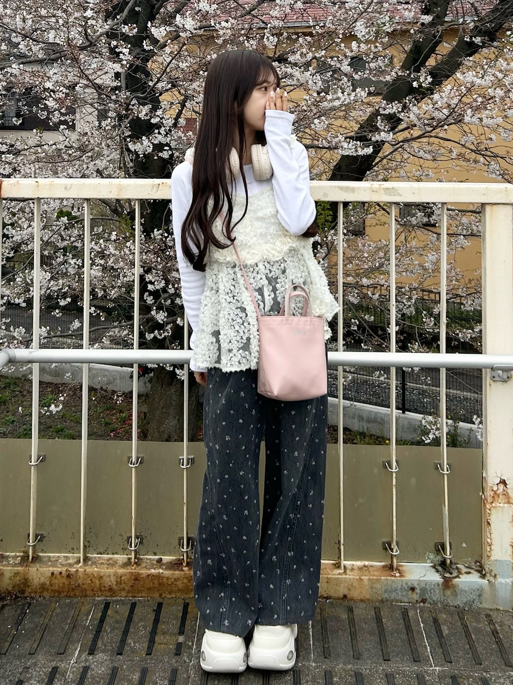 ホワイト系のスニーカー、ブラック系のデニムパンツ、ホワイト系のキャミソールを着用したレディースの春コーディネートの1枚目の写真