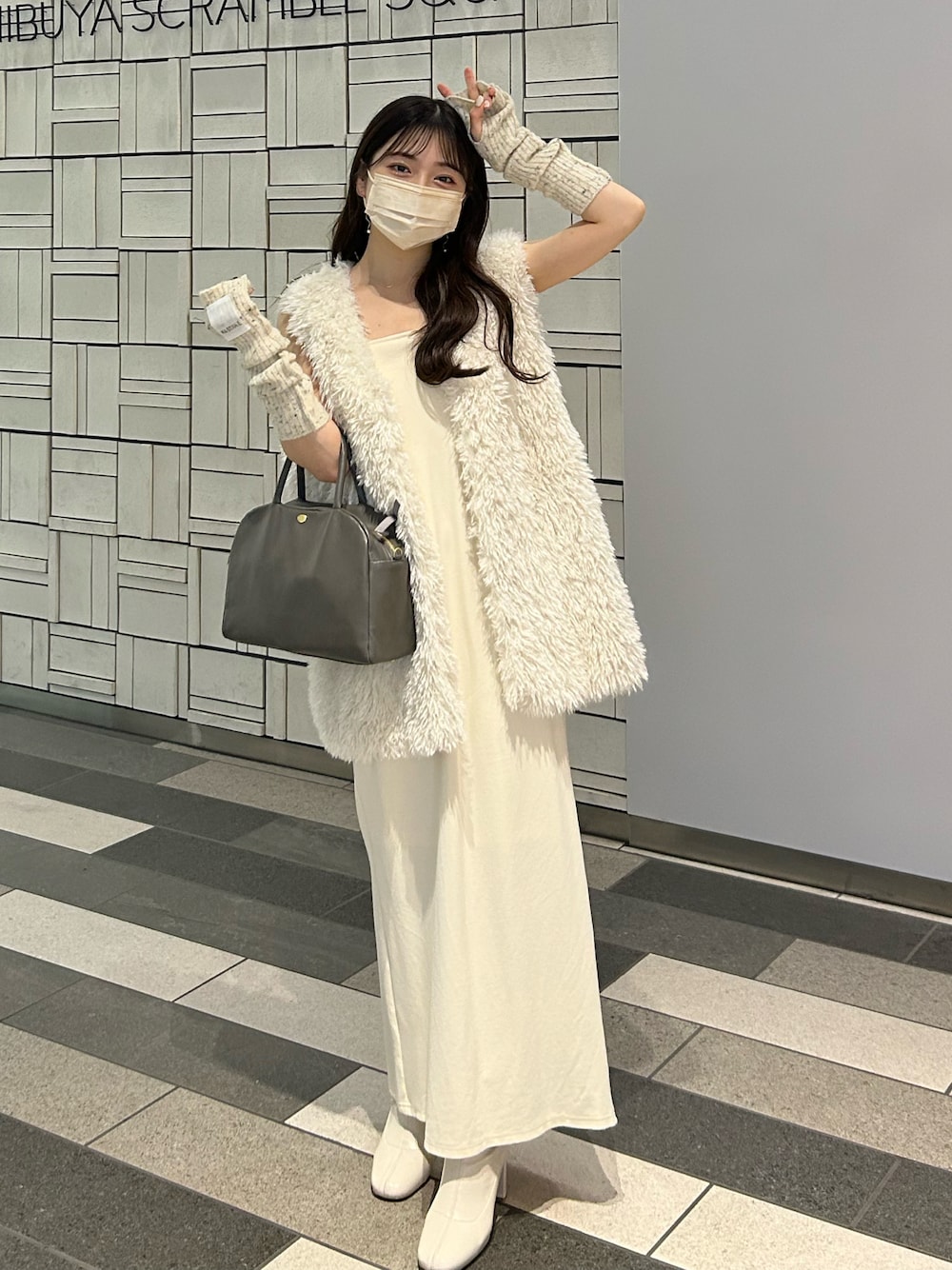 グレー系のショルダーバッグ、ホワイト系のワンピース、ホワイト系のダウンベストを着用したレディースの秋コーディネートの1枚目の写真