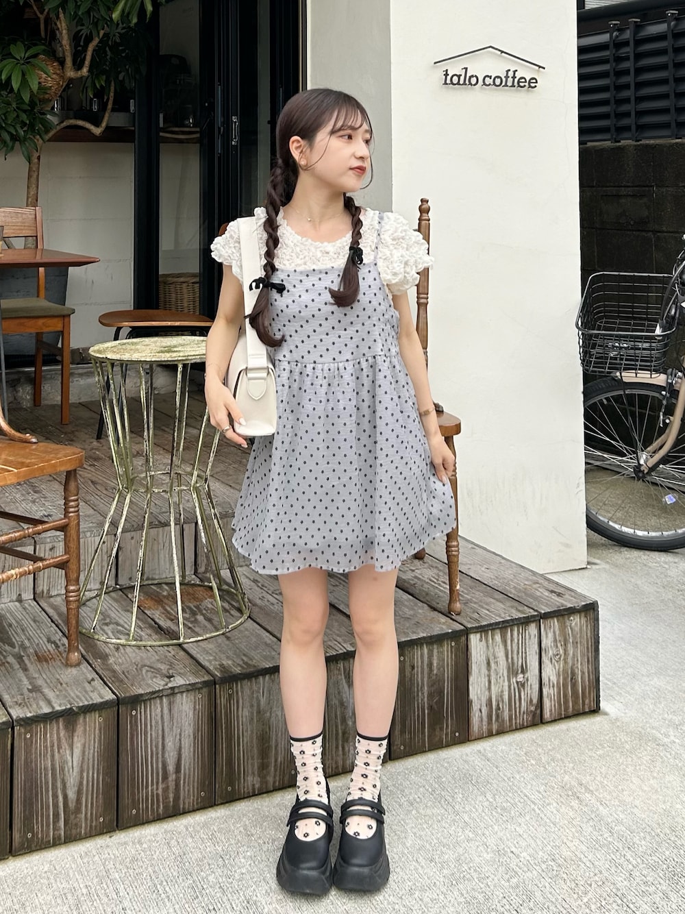 グレー系のカーディガン/ボレロ、ホワイト系のショルダーバッグ、ホワイト系のシャツ/ブラウスを着用したレディースの夏コーディネートの1枚目の写真