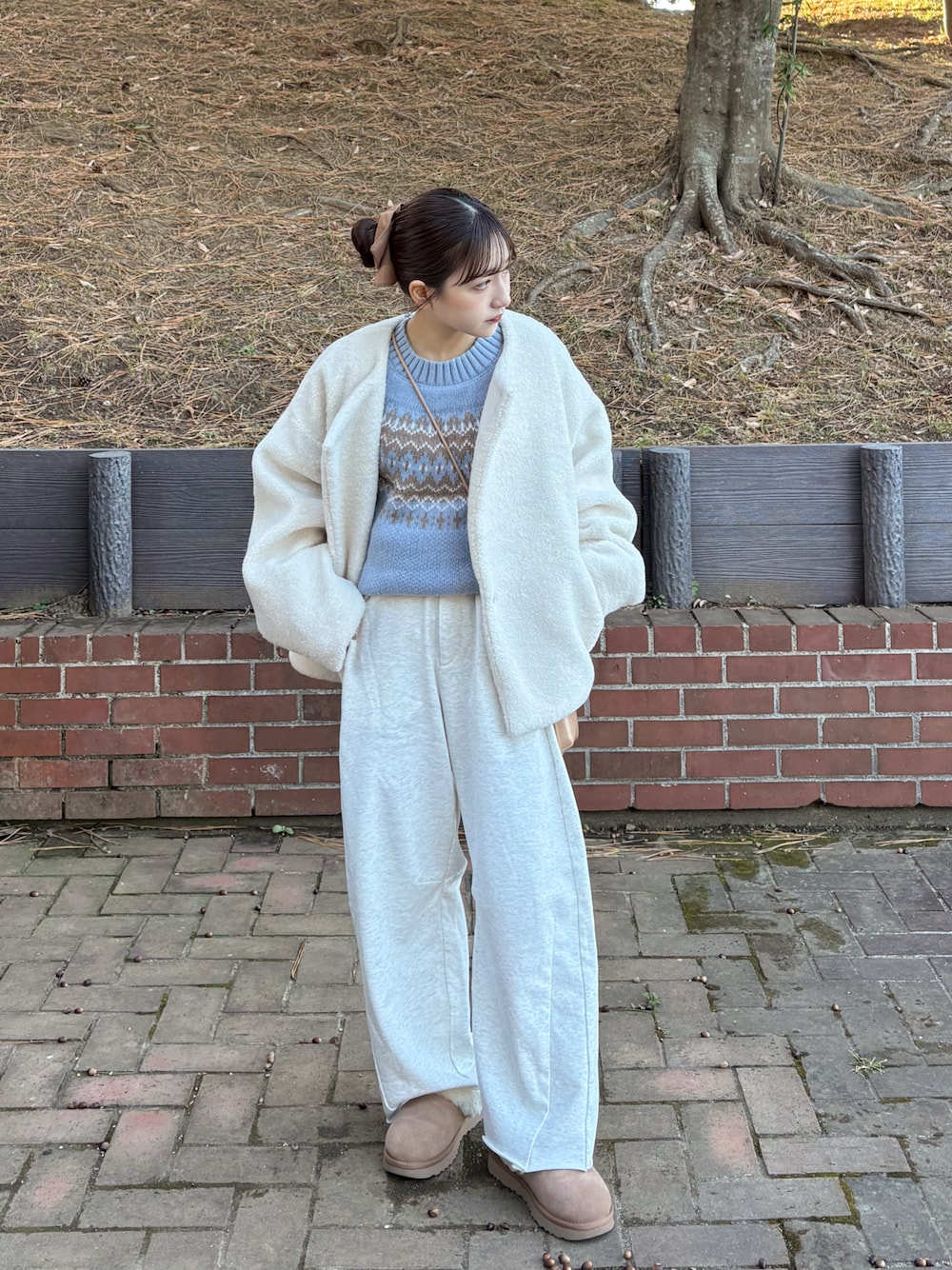 グレー系のスウェットパンツ、ホワイト系のブルゾン、ブルー系のニット/セーターを着用したレディースの冬コーディネートの1枚目の写真