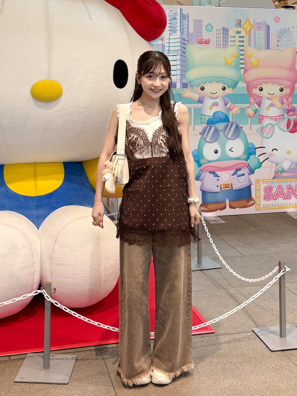ホワイト系のタンクトップ、ブラウン系のデニムパンツ、ブラウン系のキャミソールを着用したレディースの夏コーディネートの1枚目の写真