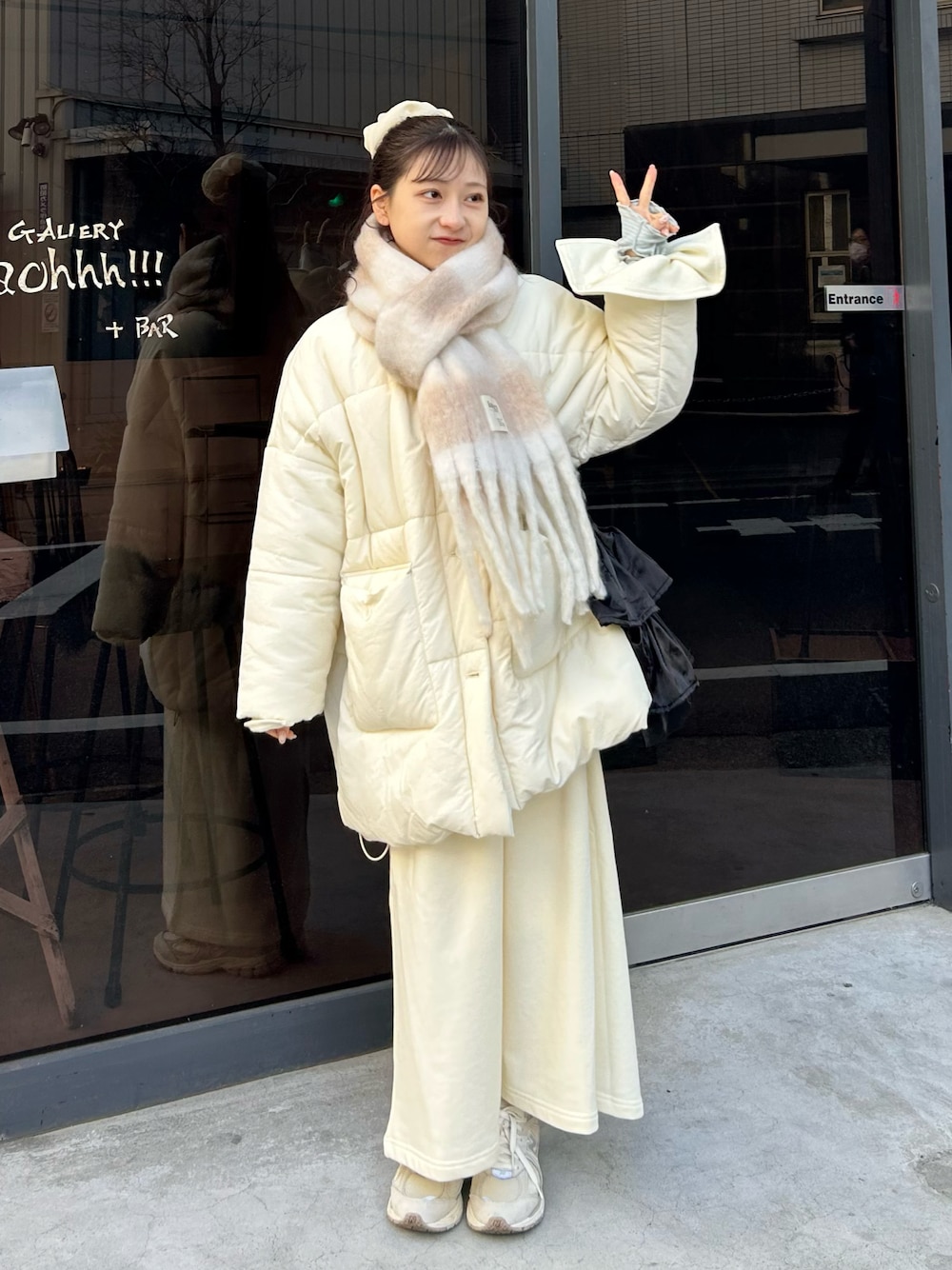 グレー系のスニーカー、ホワイト系のワンピース、ホワイト系のダウンジャケット/コートを着用したレディースの冬コーディネートの1枚目の写真