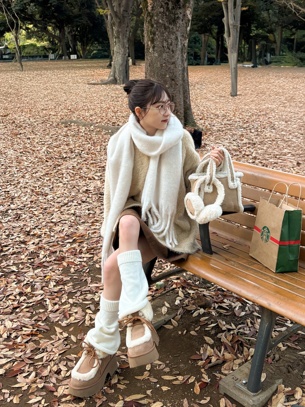 ベージュ系のブーツ、ベージュ系のカーディガン/ボレロ、ホワイト系のマフラーを着用したレディースの秋コーディネートの1枚目の写真