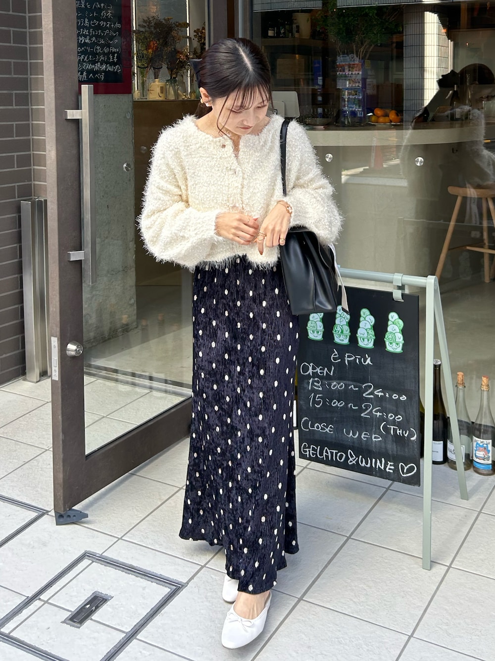 ホワイト系のカーディガン/ボレロ、ブラック系のショルダーバッグ、ホワイト系のサンダルを着用したレディースの秋コーディネートの1枚目の写真