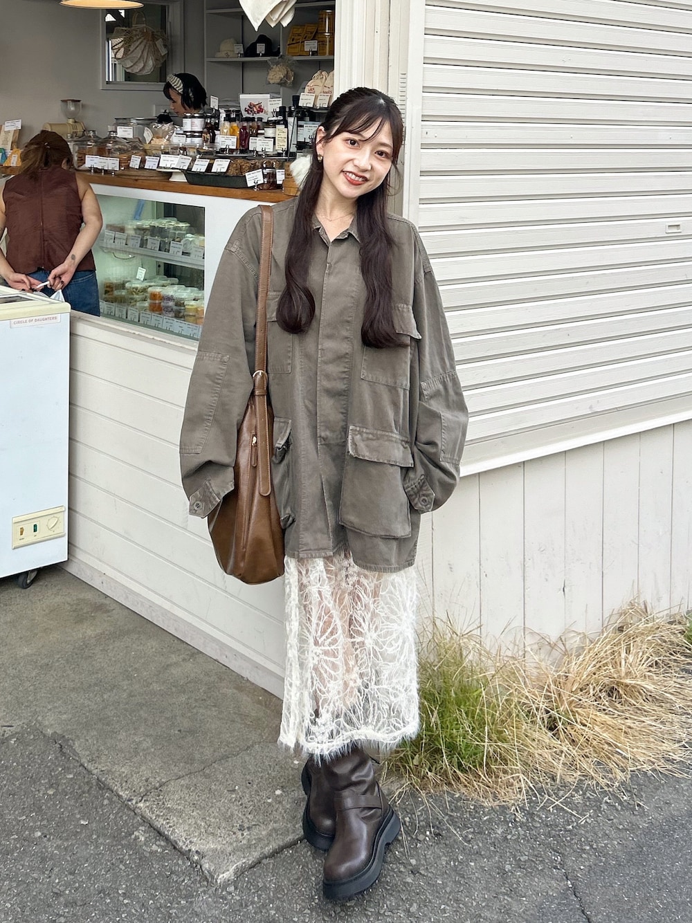 ブラウン系のデニムジャケット、ブラウン系のショルダーバッグ、ブラウン系のブーツを着用したレディースの秋コーディネートの1枚目の写真