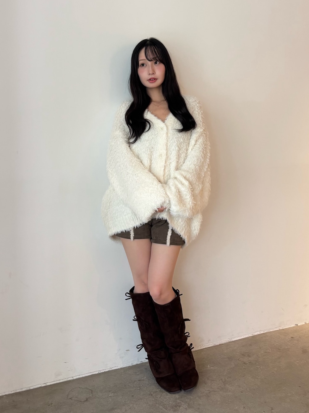 グレー系のその他パンツ、イエロー系のカーディガン/ボレロ、ブラウン系のブーツを着用したレディースの秋コーディネートの1枚目の写真