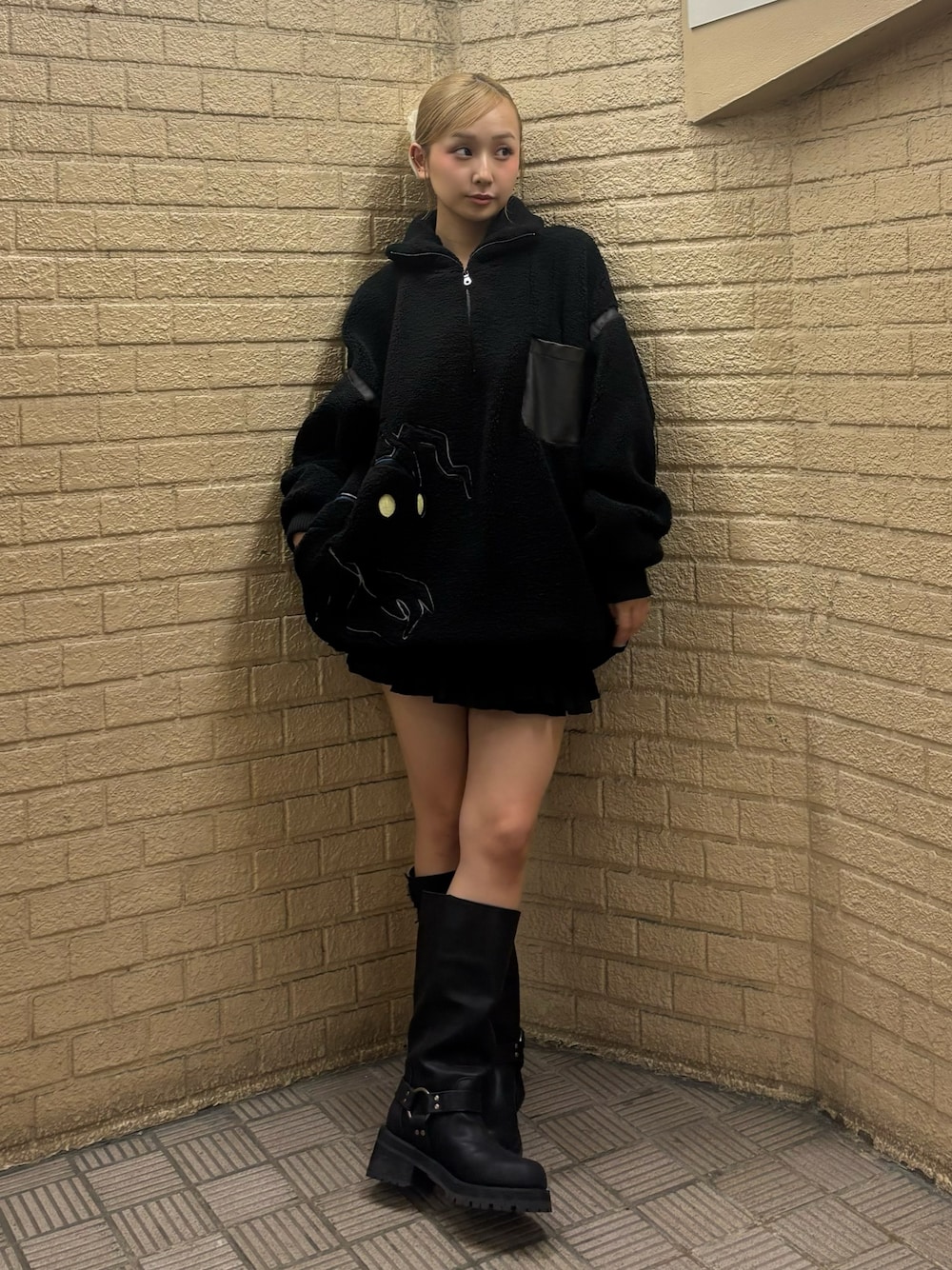 ブラック系のスウェット、ブラック系のスカート、ブラウン系のブーツを着用したレディースの秋コーディネートの1枚目の写真