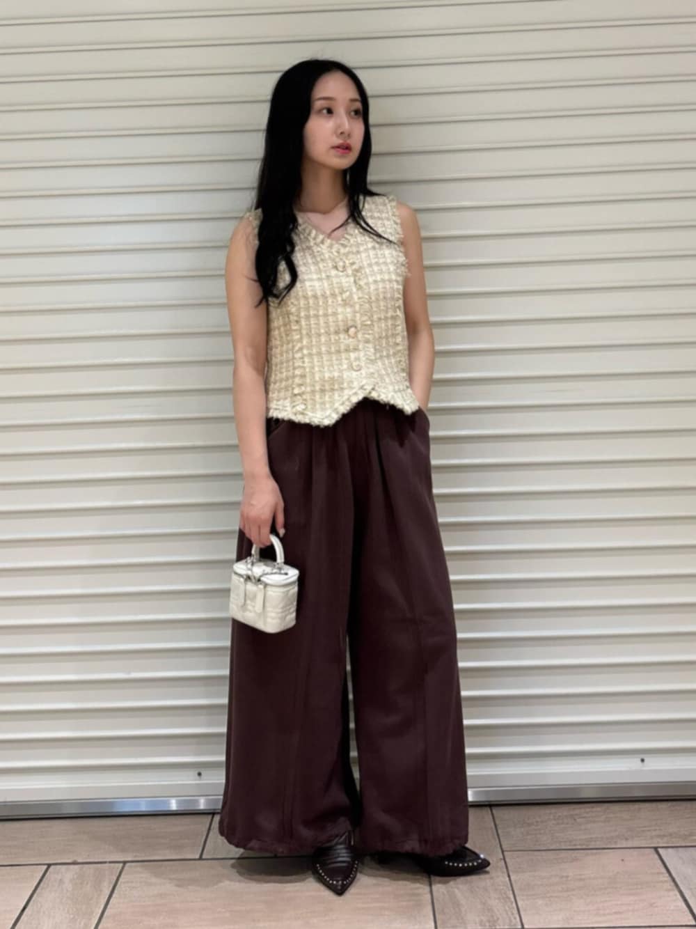 ブラウン系のサンダル、ブラウン系のスウェットパンツ、ベージュ系のベストを着用したレディースの夏コーディネートの1枚目の写真