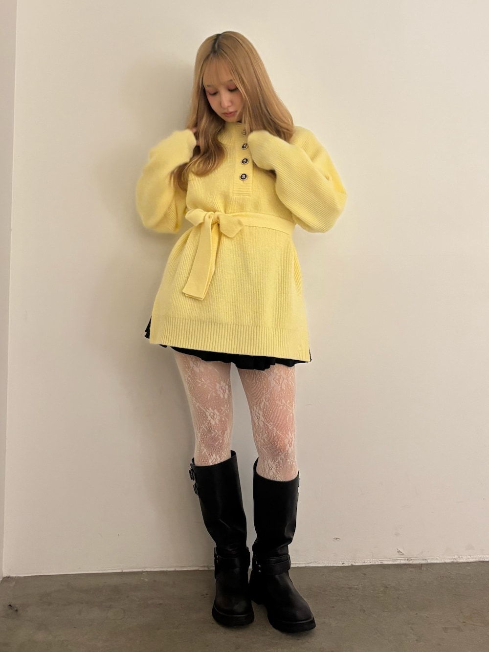 イエロー系のニット/セーター、ブラック系のその他パンツ、ブラック系のブーツを着用したレディースの秋コーディネートの1枚目の写真