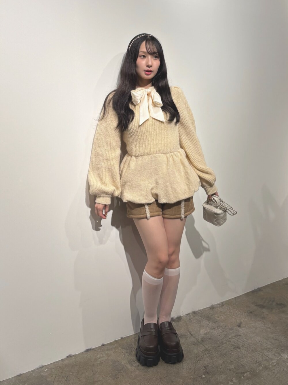ブラウン系のローファー、ベージュ系のその他パンツ、ホワイト系のニット/セーターを着用したレディースの秋コーディネートの1枚目の写真