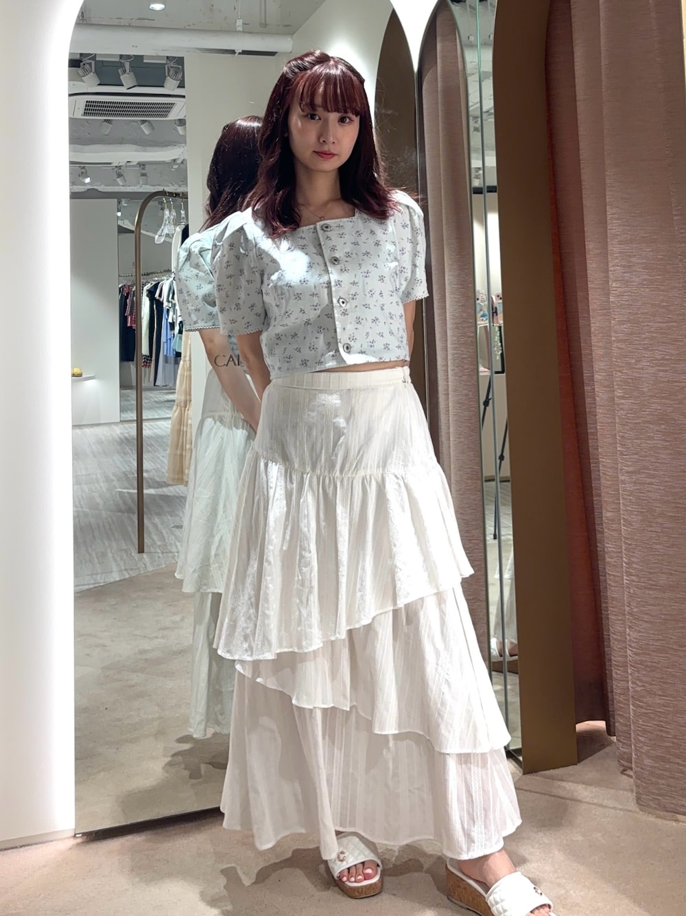 ホワイト系のスカート、ブルー系のシャツ/ブラウスを着用したレディースの春コーディネートの1枚目の写真