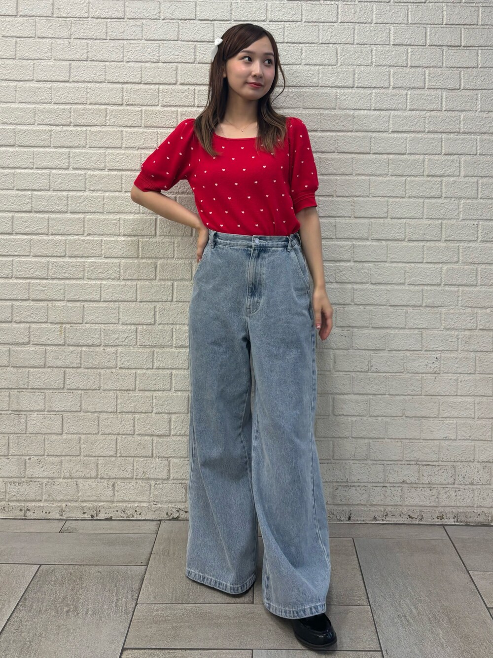 ブルー系のデニムパンツ、レッド系のニット/セーター、ブラック系のバレッタ/ヘアクリップを着用したレディースの夏コーディネートの1枚目の写真