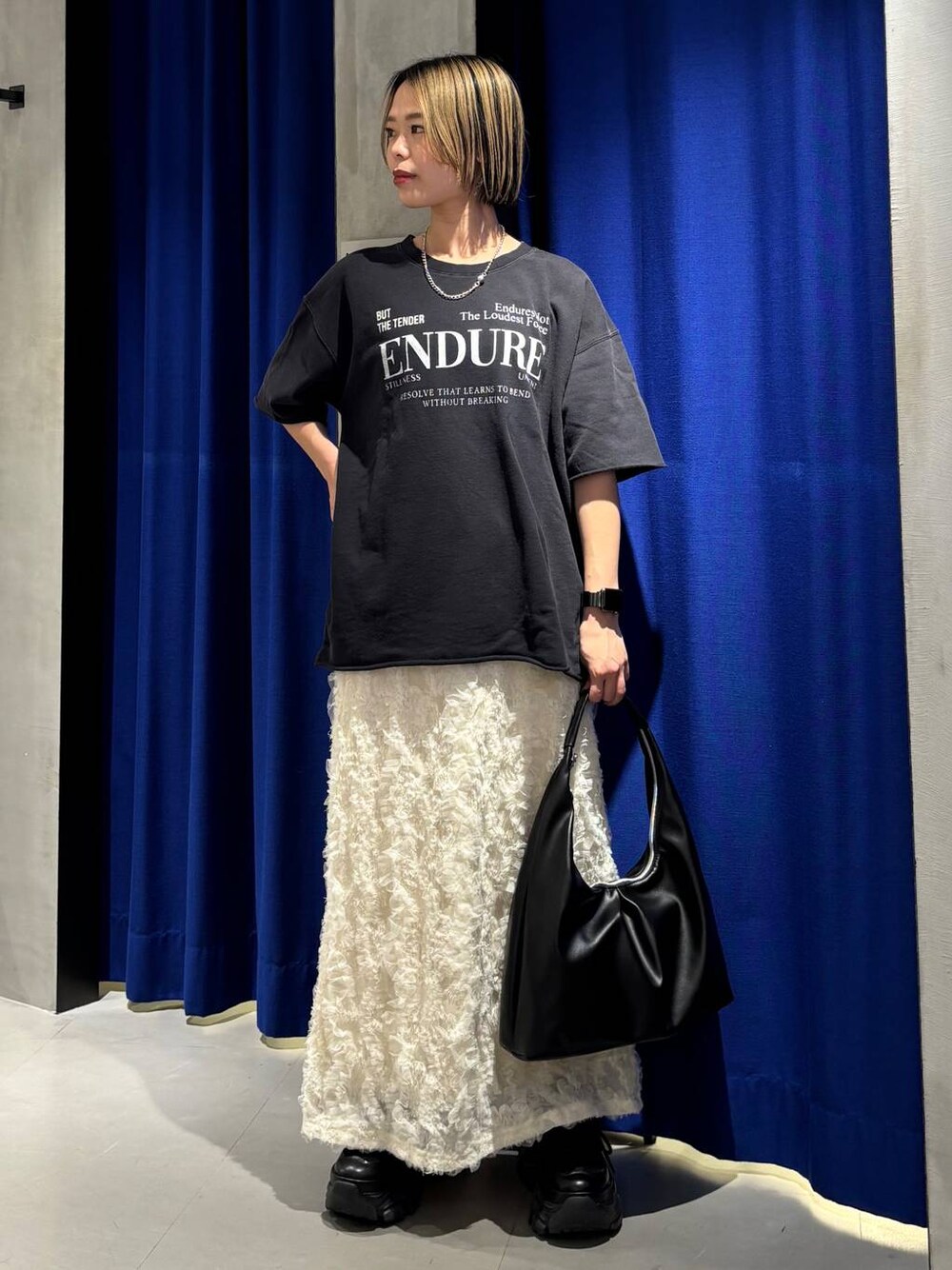 ブラック系のスニーカー、ブラック系のトートバッグ、ブラック系のTシャツ/カットソーを着用したレディースの春コーディネートの1枚目の写真