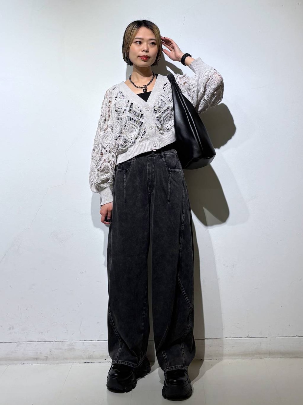 ブラック系のスニーカー、ベージュ系のカーディガン/ボレロ、ブラック系のデニムパンツを着用したレディースの春コーディネートの1枚目の写真