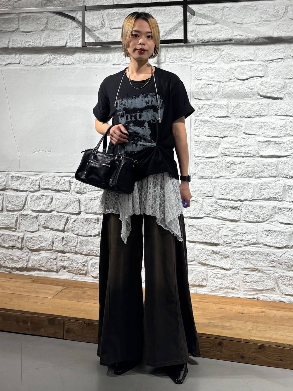 ブラウン系のデニムパンツ、ブラック系のショルダーバッグ、ブラック系のTシャツ/カットソーを着用したレディースの夏コーディネートの1枚目の写真