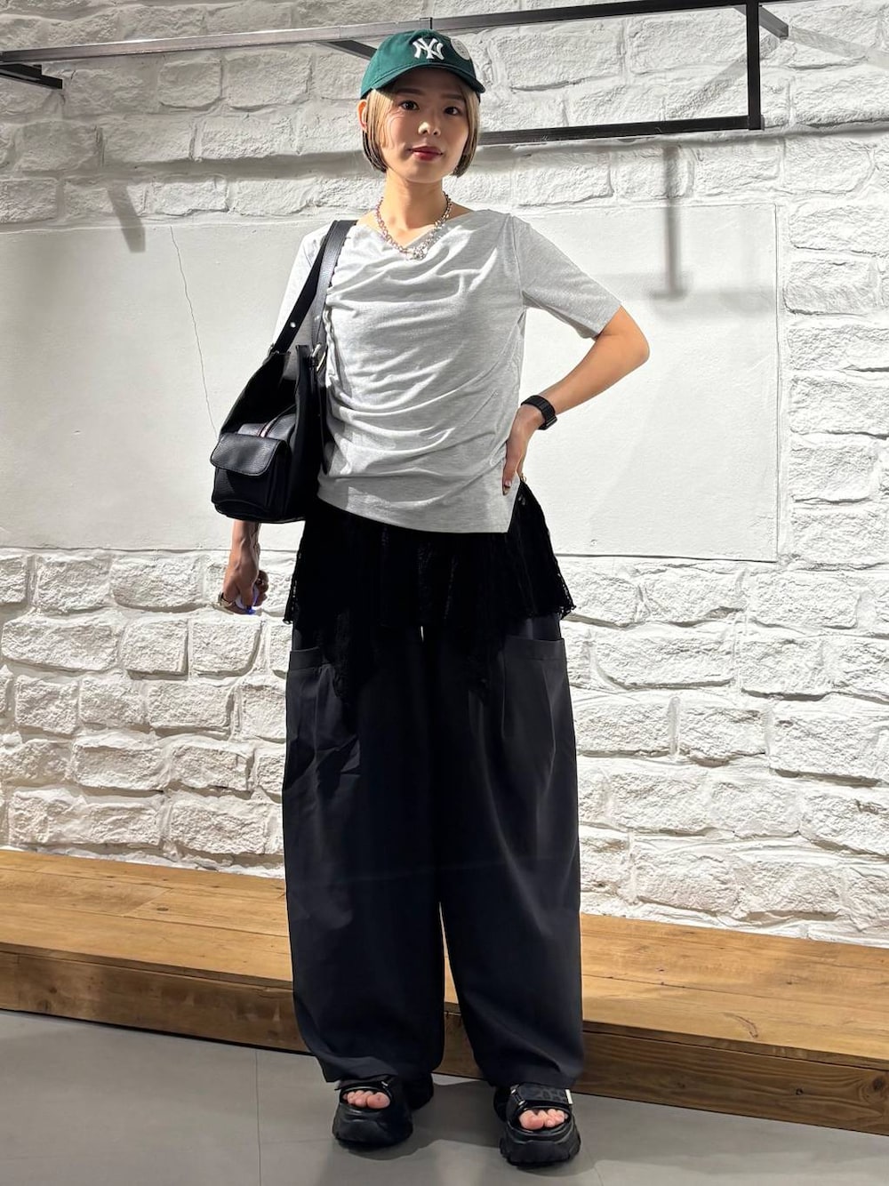 ブラック系のその他パンツ、グレー系のサンダル、ブルー系のハンドバッグを着用したレディースの春コーディネートの1枚目の写真