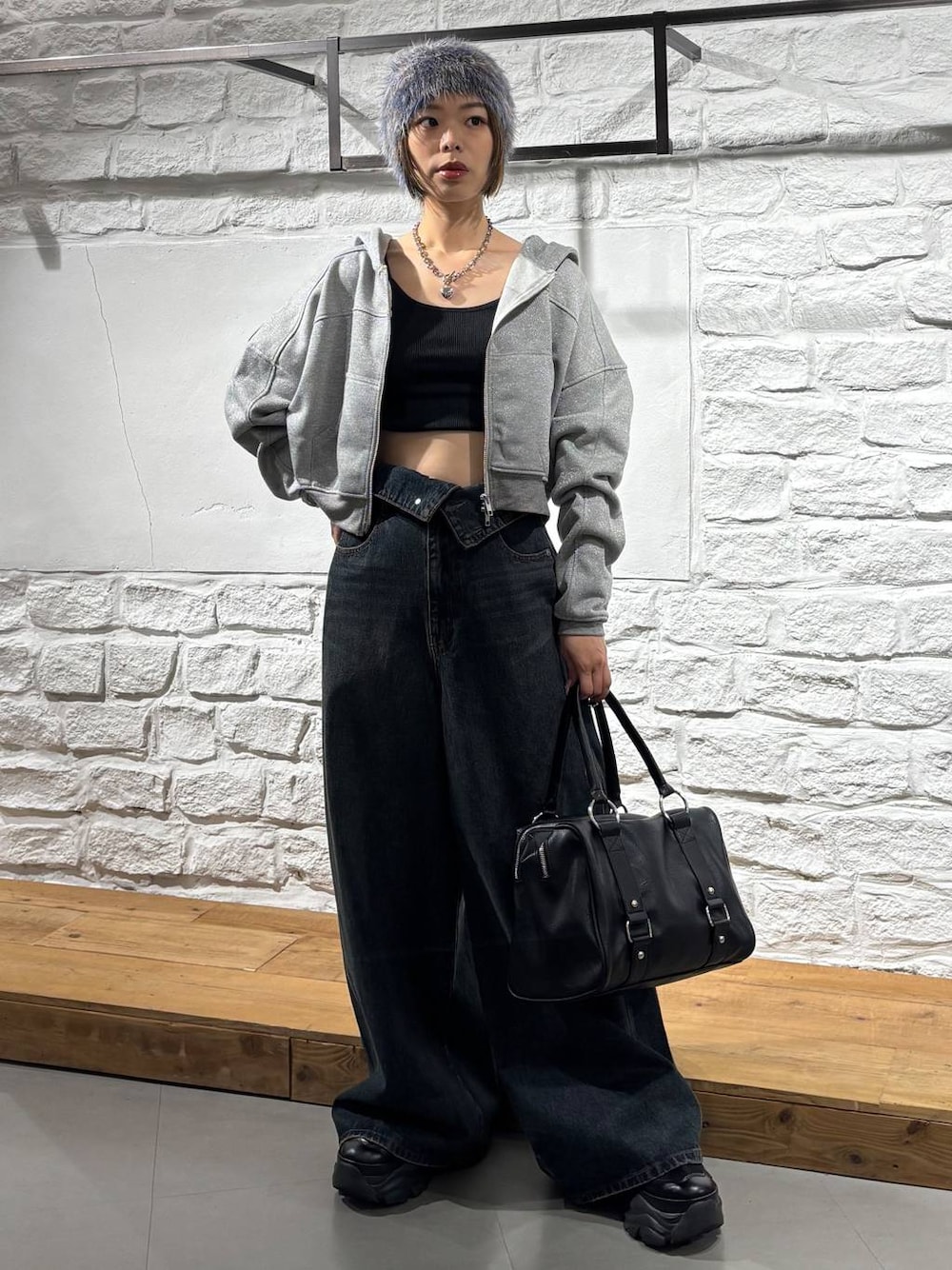 ブルー系のデニムパンツ、ブラック系のボストンバッグ、グレー系のパーカーを着用したレディースの秋コーディネートの1枚目の写真