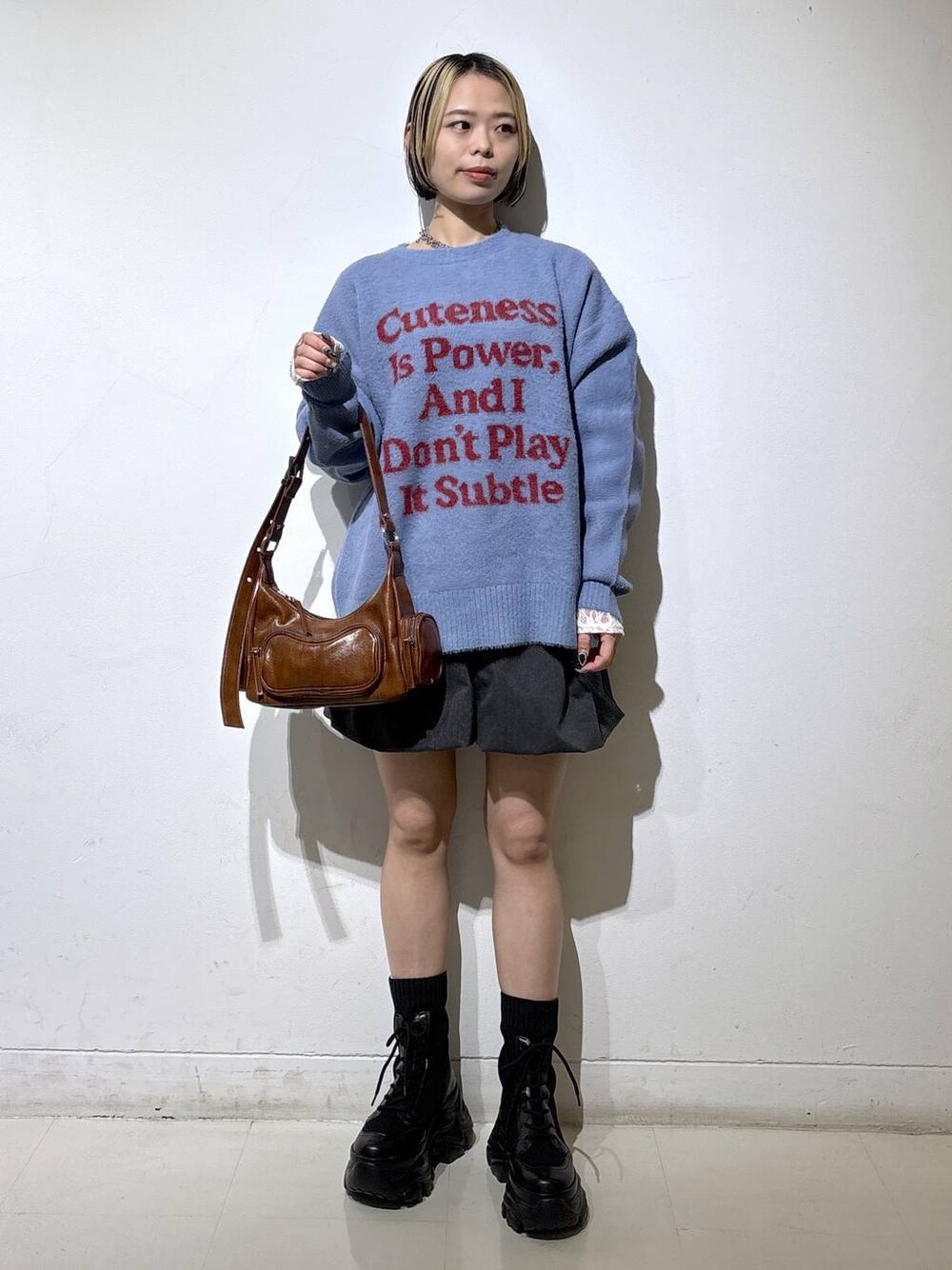 ブラック系のブーツ、ホワイト系のTシャツ/カットソー、ブラウン系のショルダーバッグを着用したレディースの冬コーディネートの1枚目の写真