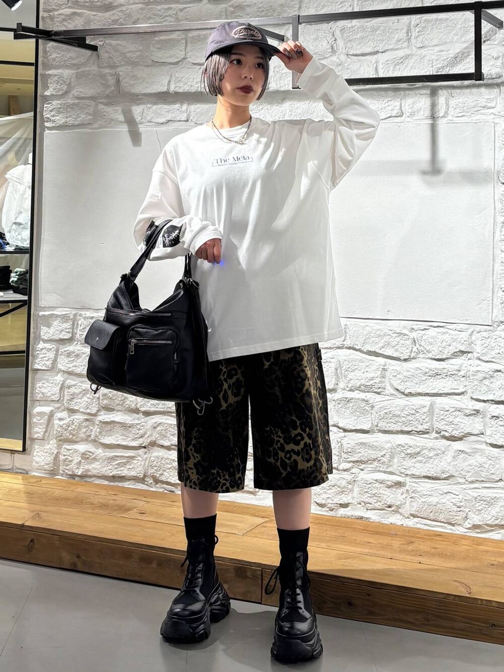 ブラック系のブーツ、その他のデニムパンツ、ブラック系のショルダーバッグを着用したレディースの春コーディネートの1枚目の写真