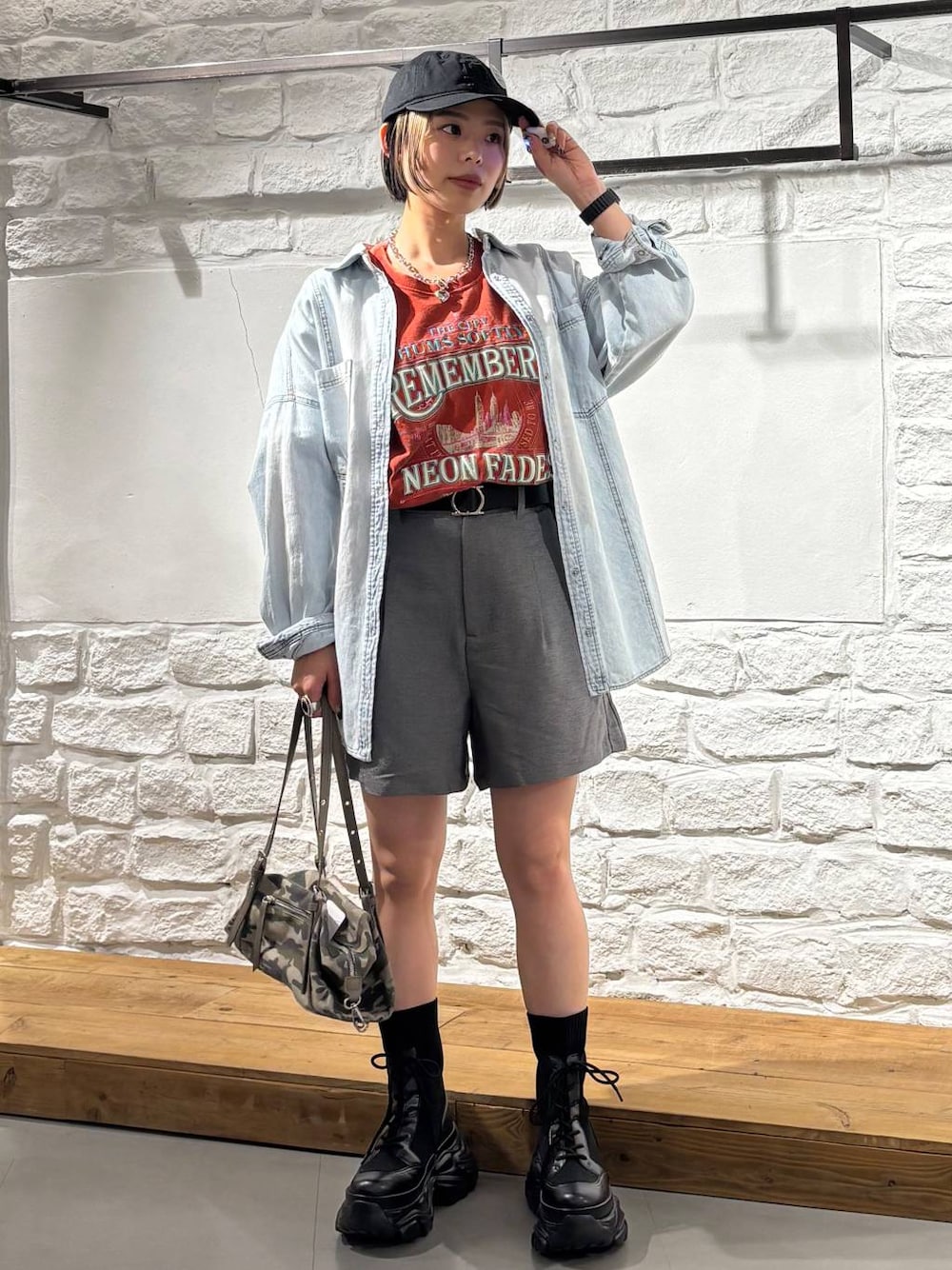 ブラック系のブーツ、ブルー系のシャツ/ブラウス、レッド系のTシャツ/カットソーを着用したレディースの春コーディネートの1枚目の写真