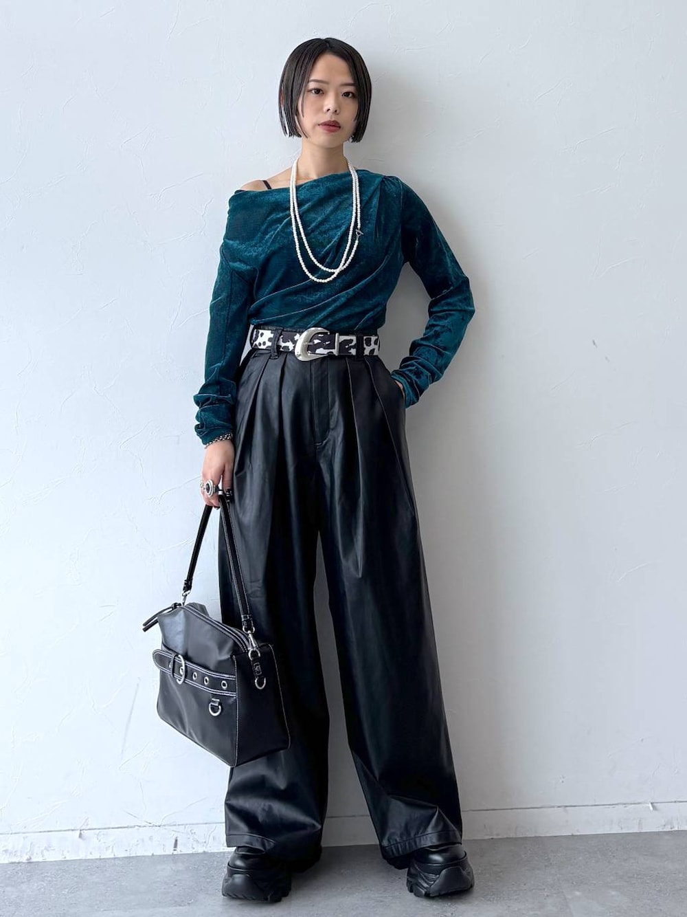 ブラック系のスニーカー、ブラック系のスラックス、ブルー系のTシャツ/カットソーを着用したレディースの秋コーディネートの1枚目の写真