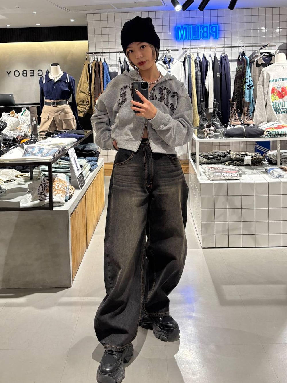 ブラック系のブーツ、ブラック系のデニムパンツ、グレー系のパーカーを着用したレディースの冬コーディネートの1枚目の写真