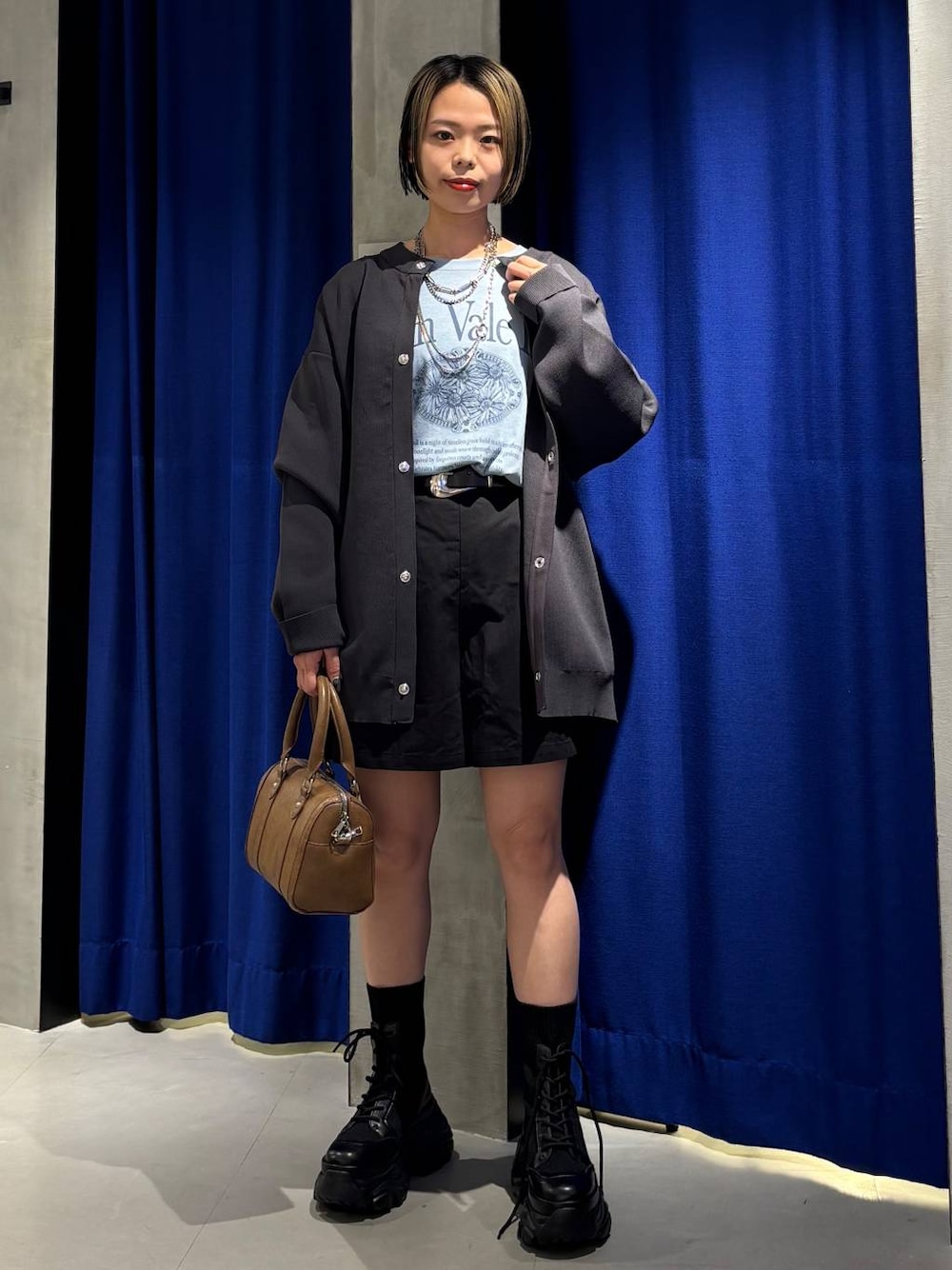 ブラック系のブーツ、ブラウン系のボストンバッグ、ブラック系のその他パンツを着用したレディースの春コーディネートの1枚目の写真