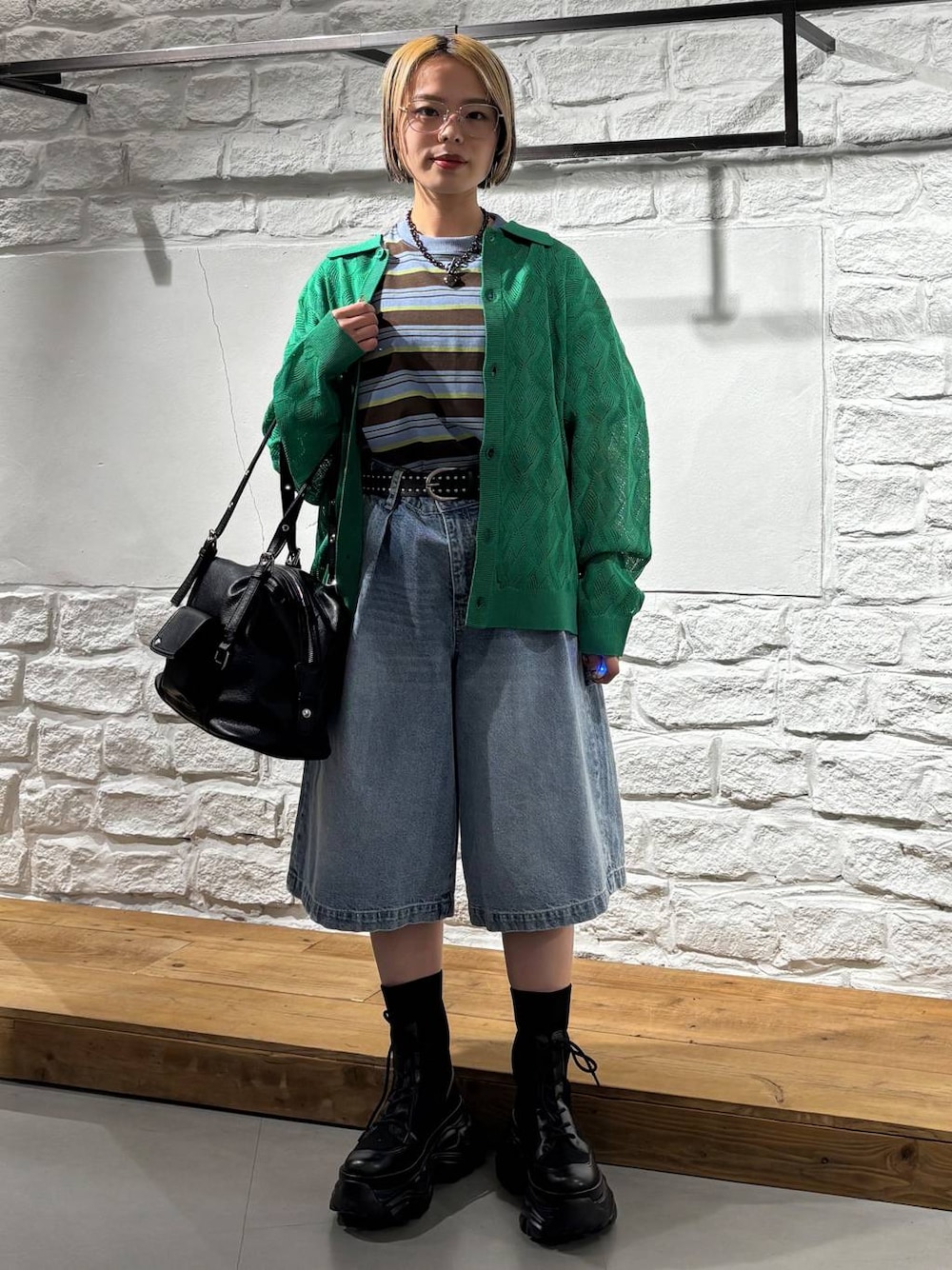ブラック系のブーツ、ブルー系のデニムパンツ、ブラウン系のTシャツ/カットソーを着用したレディースの春コーディネートの1枚目の写真