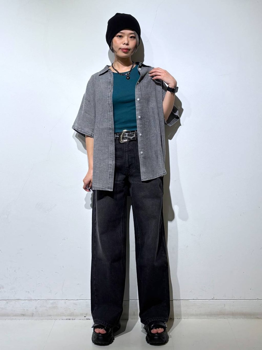 ブラック系のデニムパンツ、ブラック系のシャツ/ブラウス、グリーン系のTシャツ/カットソーを着用したレディースの春コーディネートの1枚目の写真