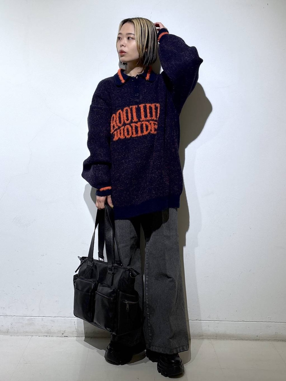 ブラック系のブーツ、ブラック系のボストンバッグ、ブルー系のニット/セーターを着用したレディースの秋コーディネートの1枚目の写真