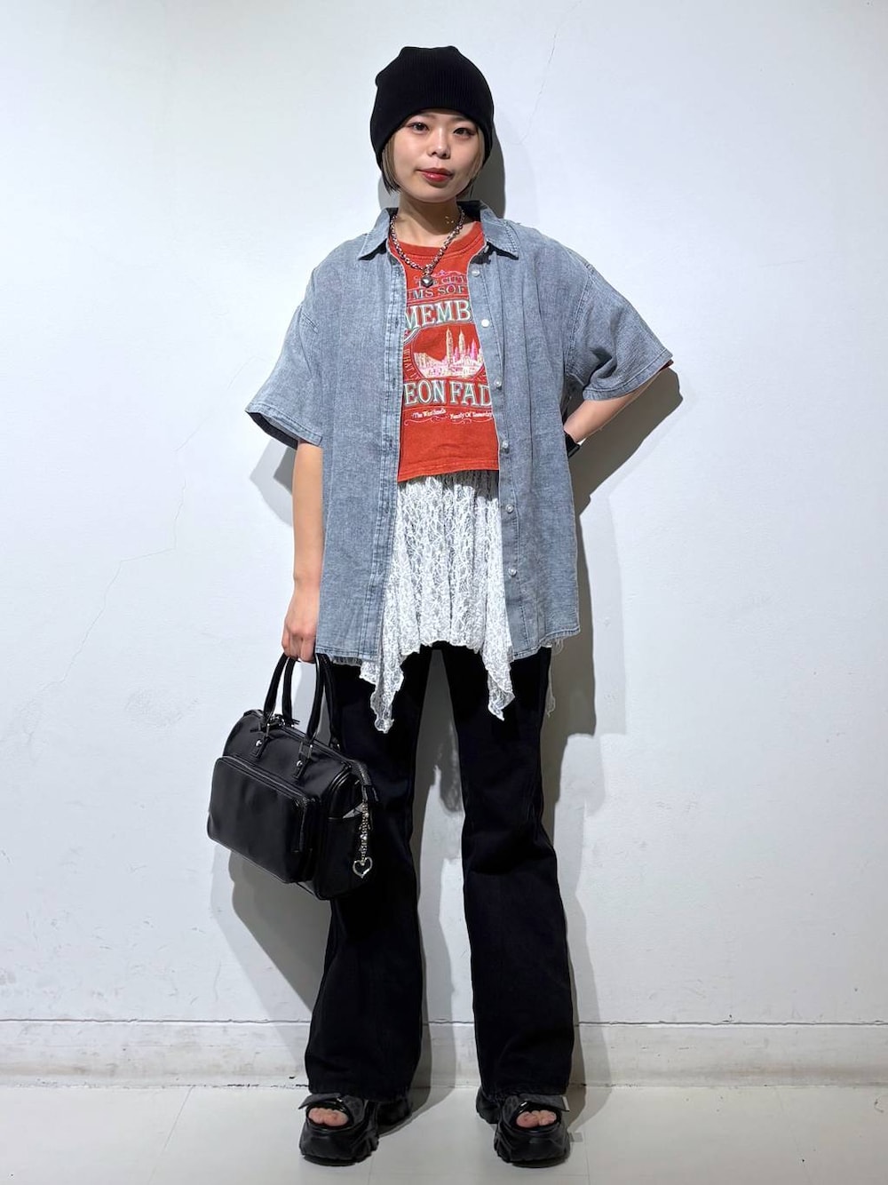 ブラック系のデニムパンツ、ブラック系のショルダーバッグ、ブルー系のシャツ/ブラウスを着用したレディースの春コーディネートの1枚目の写真