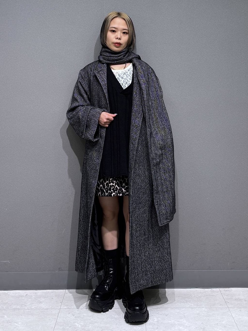 ブラック系のブーツ、ブラック系のチェスターコート、ホワイト系のTシャツ/カットソーを着用したレディースの冬コーディネートの1枚目の写真