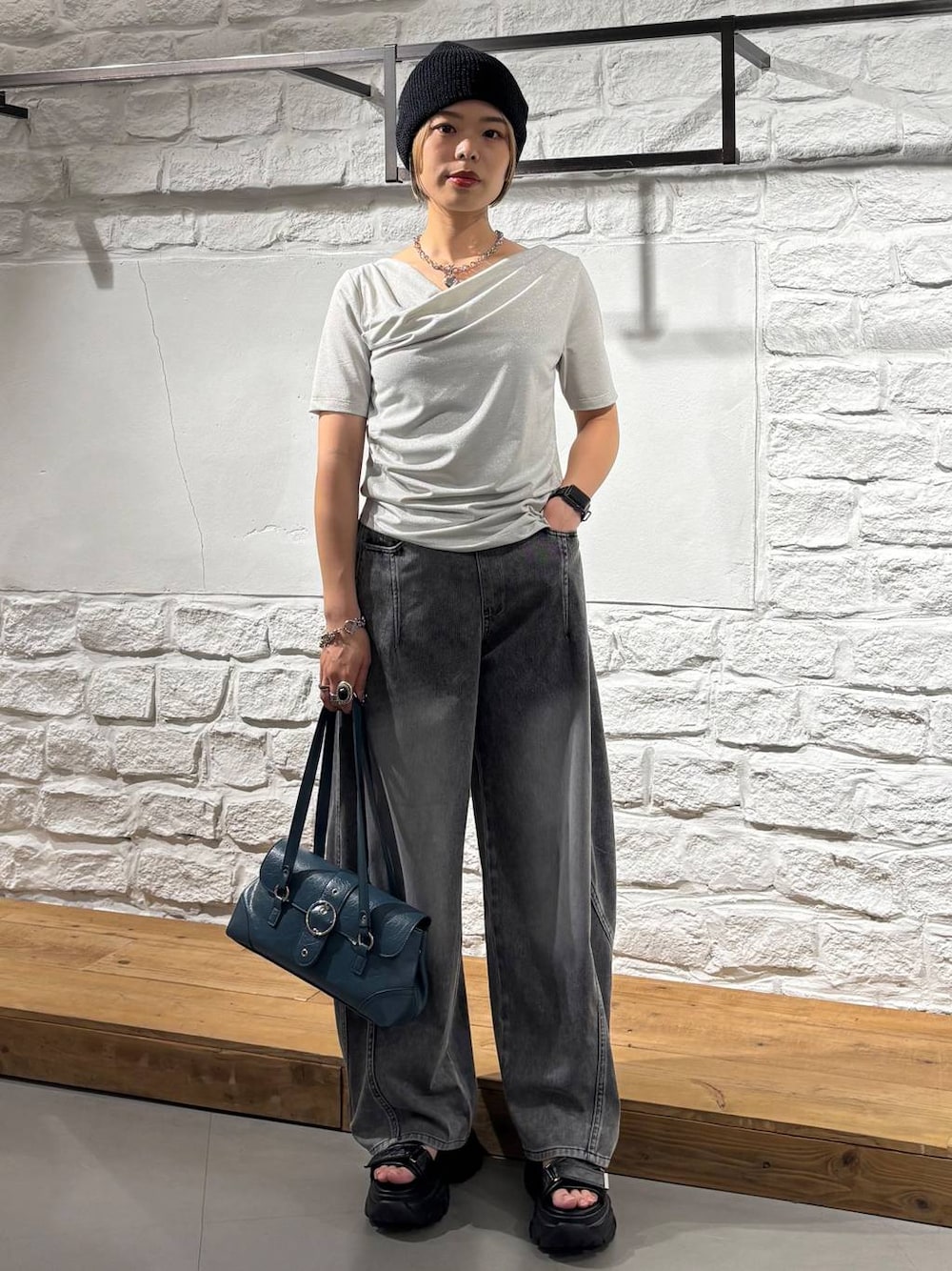 ブラック系のデニムパンツ、グレー系のサンダル、ベージュ系のTシャツ/カットソーを着用したレディースの夏コーディネートの1枚目の写真