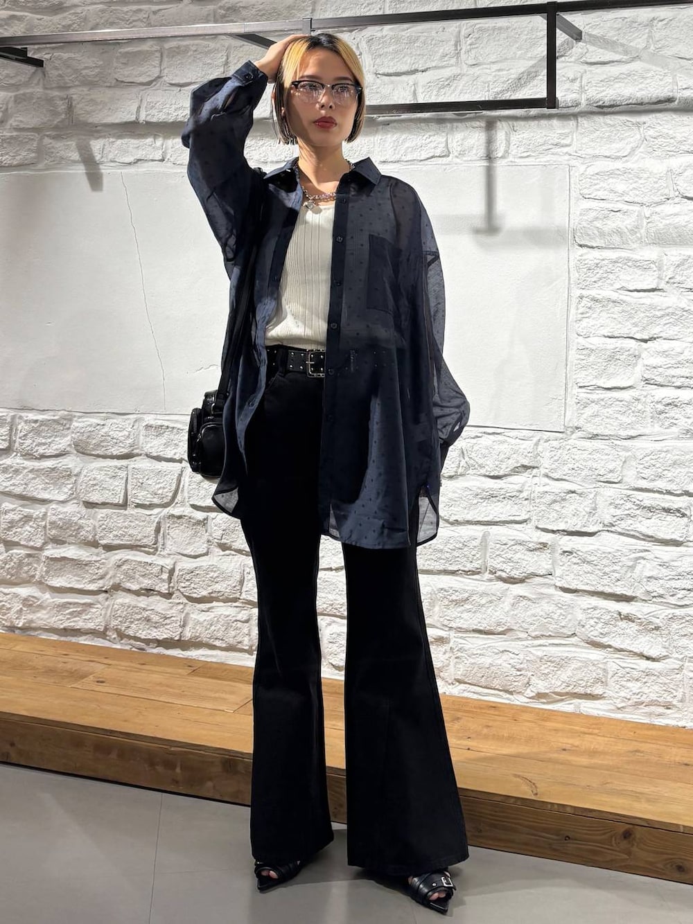ブラック系のデニムパンツ、ホワイト系のタンクトップ、ブラック系のショルダーバッグを着用したレディースの夏コーディネートの1枚目の写真