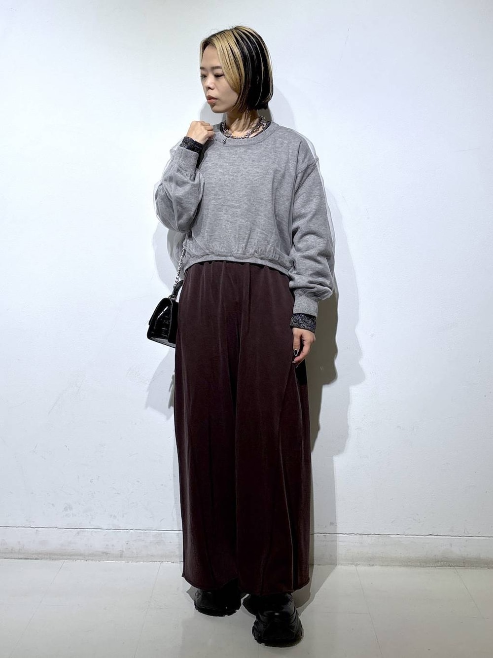 ブラック系のブーツ、シルバー系のTシャツ/カットソー、ブラウン系のスウェットパンツを着用したレディースの秋コーディネートの1枚目の写真