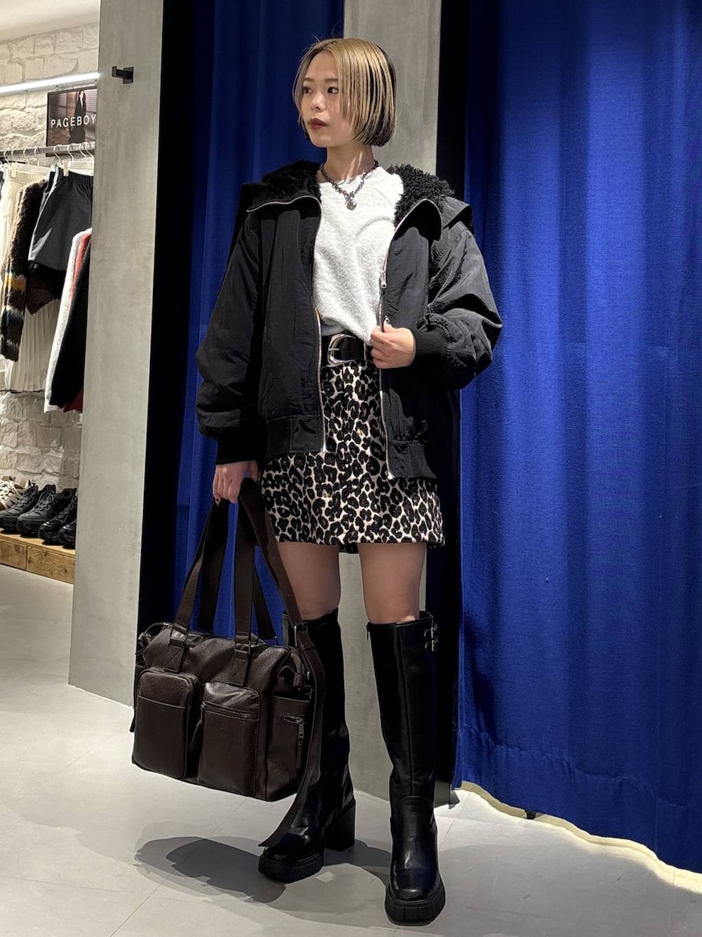 ブラック系のブーツ、ブラウン系のボストンバッグ、ブラック系のブルゾンを着用したレディースの冬コーディネートの1枚目の写真