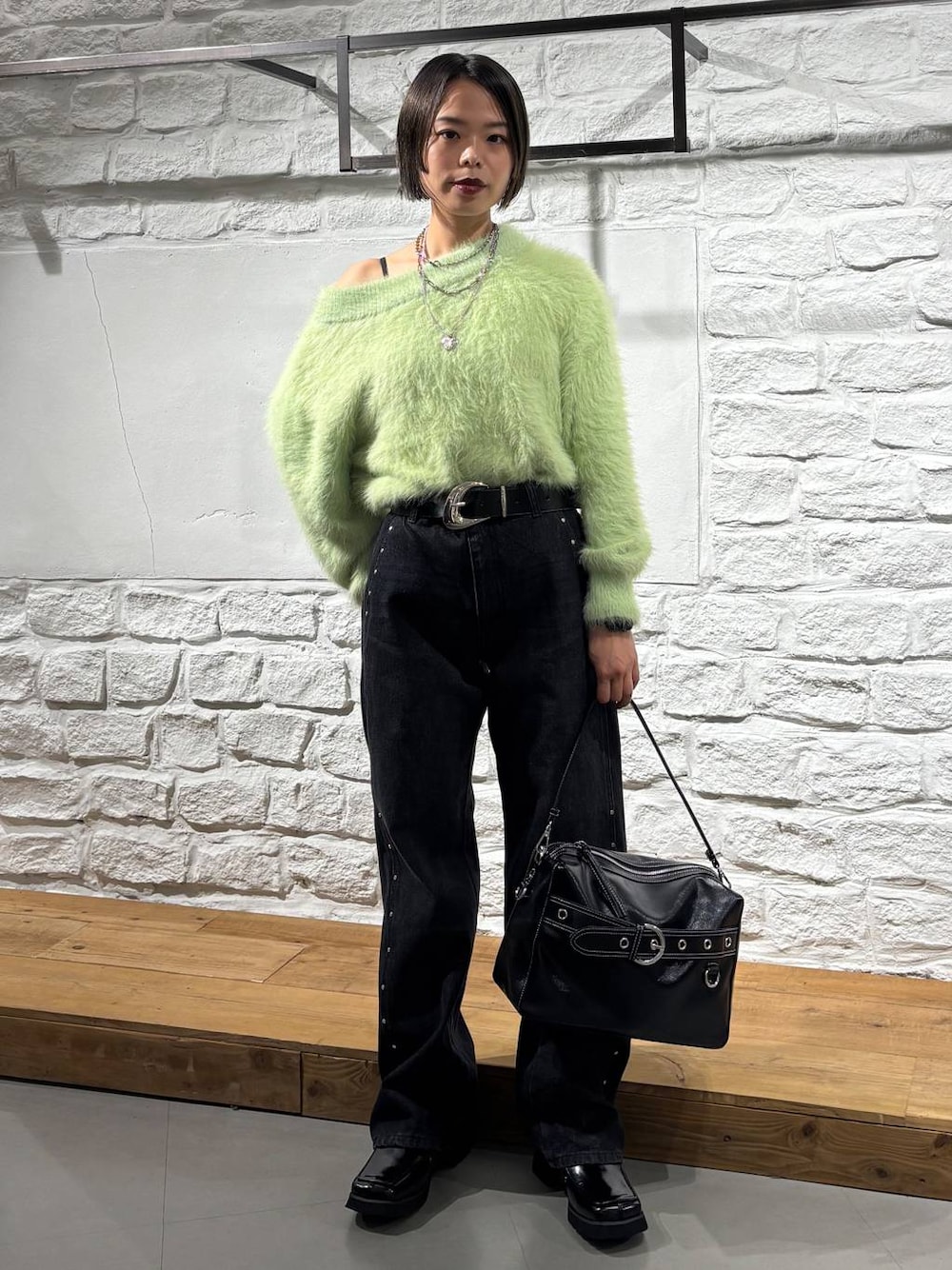 ブラック系のブーツ、ブラック系のデニムパンツ、ブラック系のショルダーバッグを着用したレディースの秋コーディネートの1枚目の写真