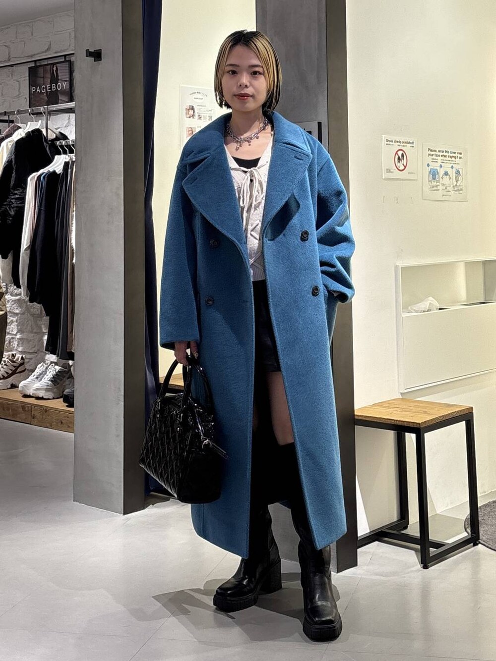 グリーン系のチェスターコート、ブラック系のブーツ、ブラック系のその他パンツを着用したレディースの冬コーディネートの1枚目の写真