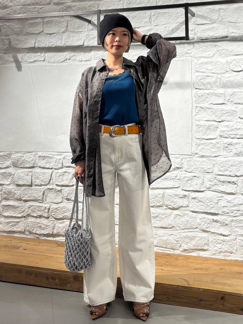 ホワイト系のデニムパンツ、シルバー系のショルダーバッグ、イエロー系のサンダルを着用したレディースの春コーディネートの1枚目の写真