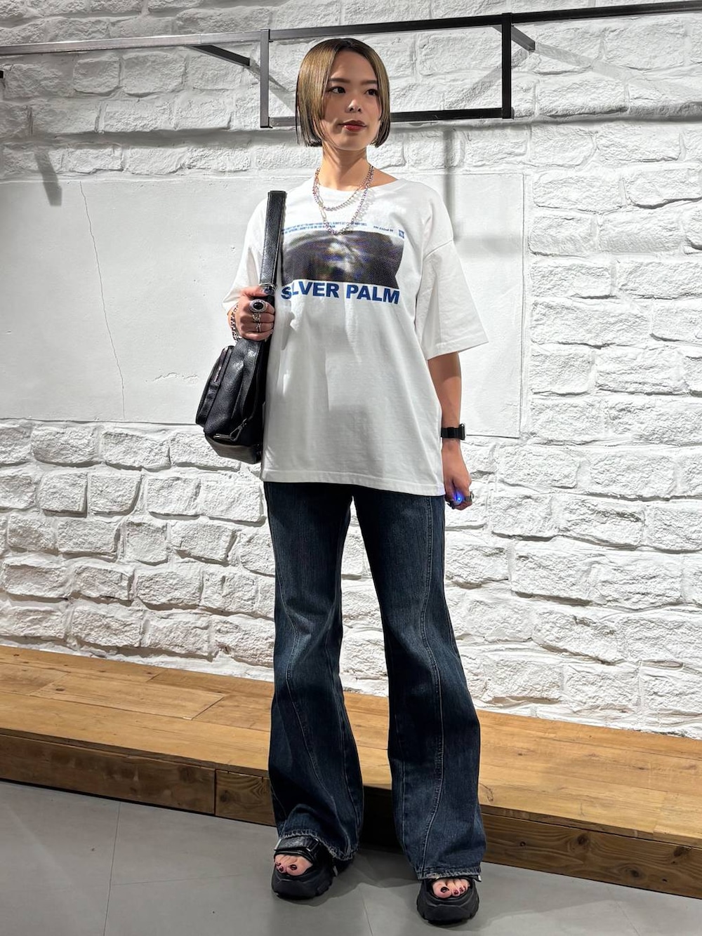 ホワイト系のTシャツ/カットソー、ブルー系のデニムパンツ、ブラック系のショルダーバッグを着用したレディースの夏コーディネートの1枚目の写真