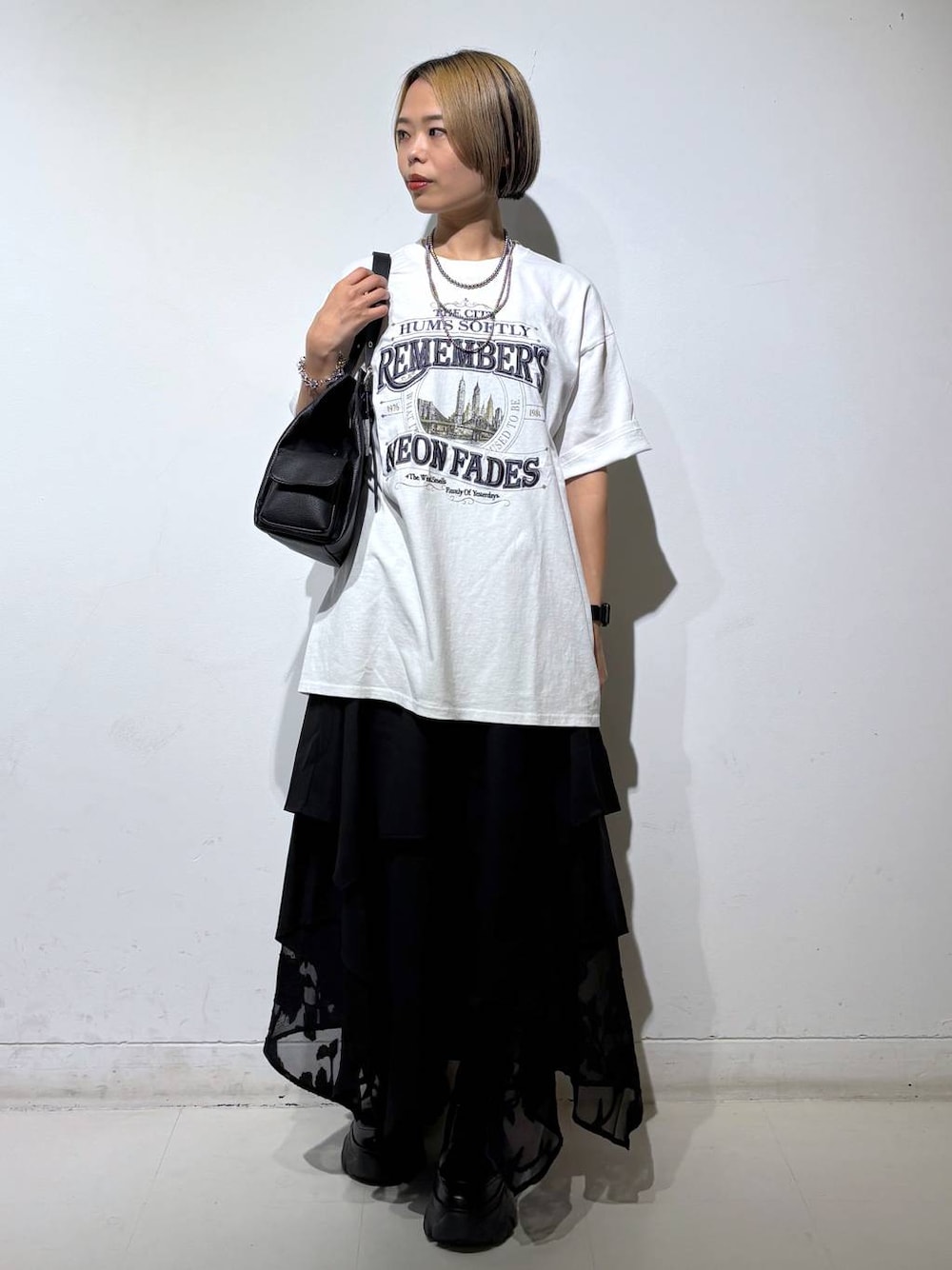 ブラック系のブーツ、ホワイト系のTシャツ/カットソー、ブラック系のハンドバッグを着用したレディースの夏コーディネートの1枚目の写真