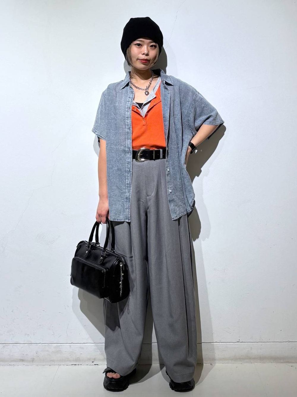 ブラック系のショルダーバッグ、グレー系のスラックス、グレー系のタンクトップを着用したレディースの春コーディネートの1枚目の写真