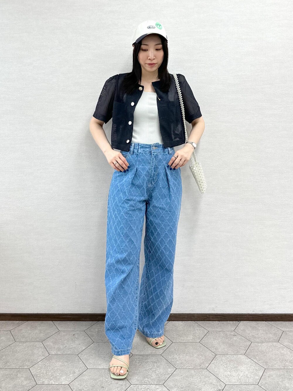 ホワイト系のショルダーバッグ、グレー系のノーカラージャケット、ブルー系のデニムパンツを着用したレディースの夏コーディネートの1枚目の写真