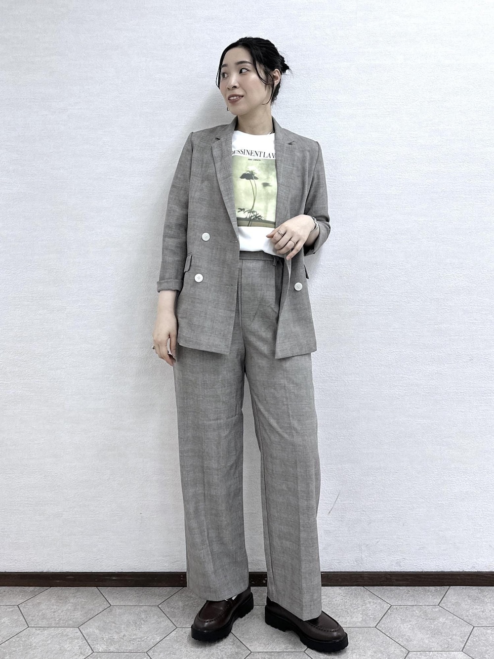 ベージュ系のテーラードジャケット、ベージュ系のスラックス、ホワイト系のTシャツ/カットソーを着用したレディースの春コーディネートの1枚目の写真