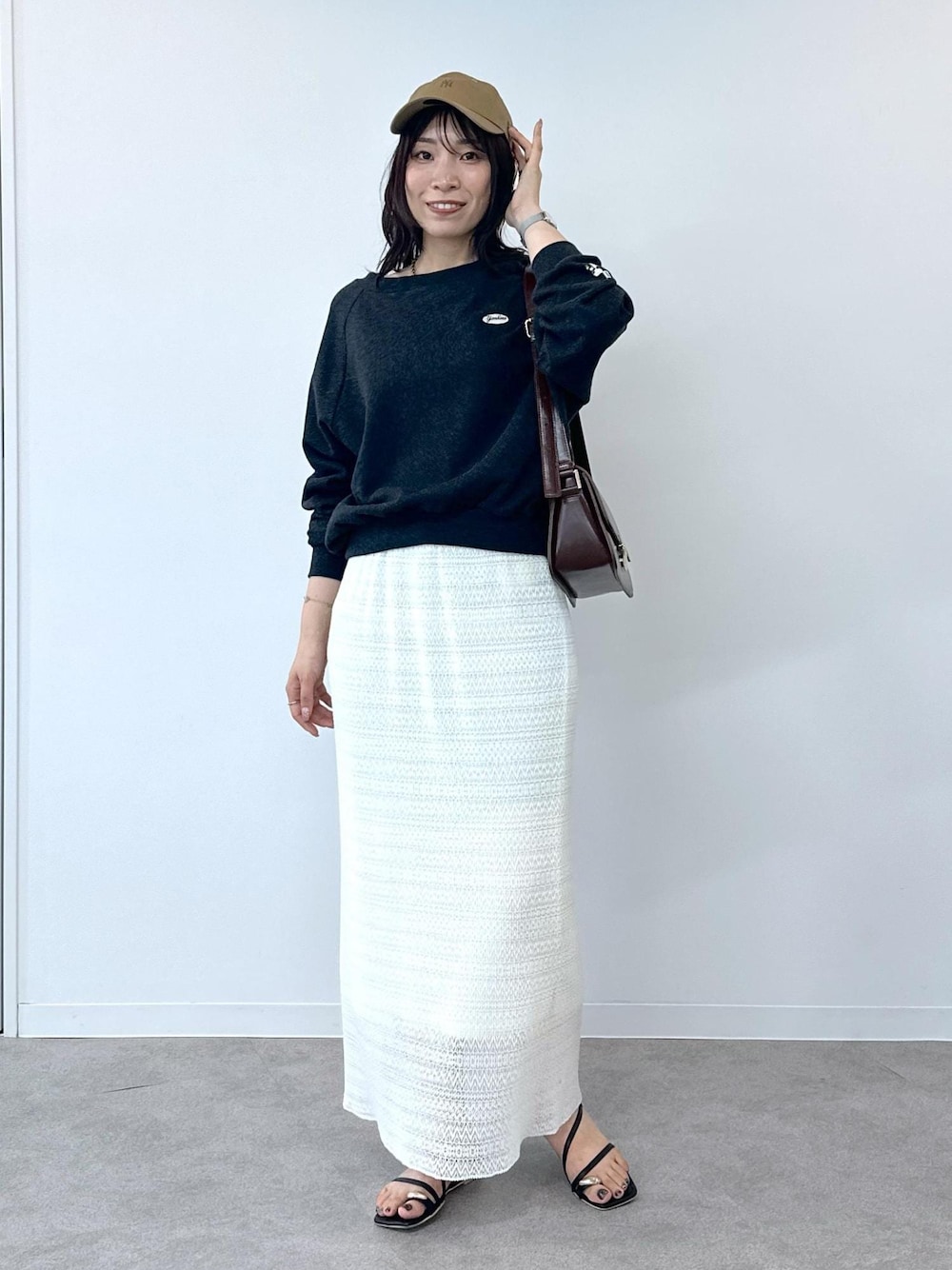 ブラック系のサンダル、ホワイト系のスカート、レッド系のショルダーバッグを着用したレディースの夏コーディネートの1枚目の写真